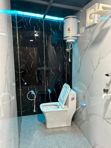 a bathroom with a toilet with a black wall at LA Foresta resort by Utopia in Shivpuri