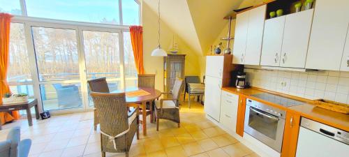 青斯特Residenz am Strand Wohnung 2-39的带桌子的厨房和餐厅