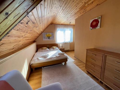 斯塔拉·里斯拉Apartmánový dom Anna的阁楼卧室设有1张床和木制天花板