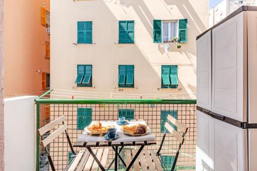 热那亚Appt Monolocale Mare & Gaslini Wi-Fi Veloce的阳台上的桌子上放着一盘食物