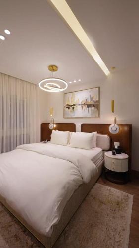 a large bedroom with a large bed with white sheets at Mountain View i city October in 6th Of October