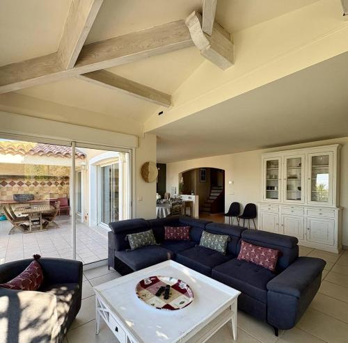 a living room with a blue couch and a table at Villa piscine privée superbe Vue Etang Leucate 8JBART580 in Port Leucate