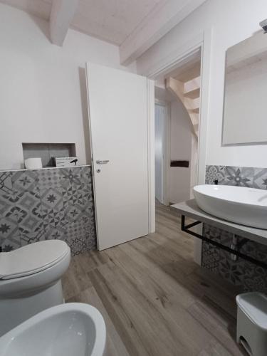 Pozzomaggioresa Domo Antiga的带马桶和水槽的白色浴室