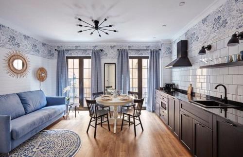 Una sala de estar con un sofá azul y una mesa. en "Breeze" Aparthotel by Parrot`s House, en Lloret de Mar