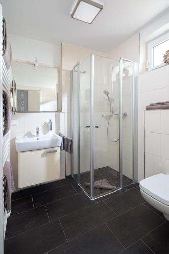 a bathroom with a shower and a sink and a toilet at Sonnendeck 14 in Norderney