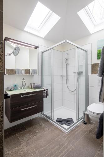 a bathroom with a glass shower and a sink at SeaSide in Norderney
