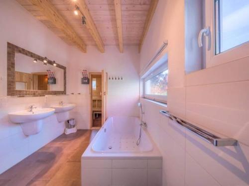 a bathroom with a tub and a sink and a tub at XXL Familienferienhaus in Granzow