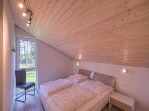 a bed in a room with a wooden ceiling at XXL Familienferienhaus in Granzow