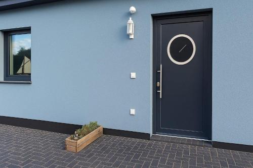 una casa blu con una porta nera e una finestra di Dat-Fischerhuus-Ankerplatz-zwischen-Bodden-und-Ostsee-in-30-sek-am-Hafen a Pruchten