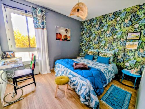 a bedroom with a bed with a blue comforter at La Villa Bleue in Beauchastel