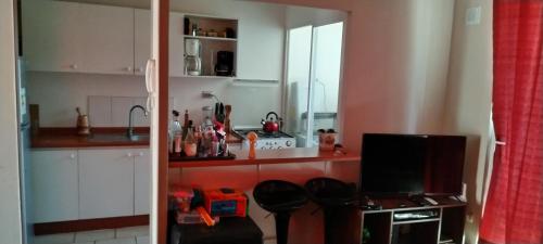 una cucina con bancone e una TV in camera di Departamento en Condominio Bosques de El Tabo a El Tabo
