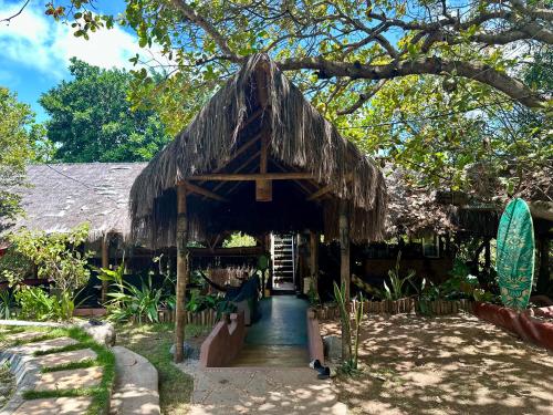 a building with a thatched roof and a pathway at Mapu in Pipa