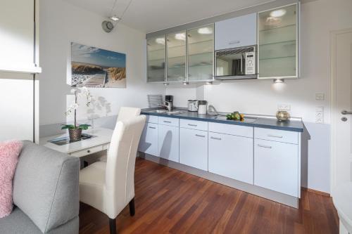 una cucina con armadietti bianchi e una scrivania di Ney la Meer a Norderney