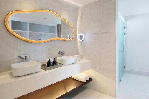 un bagno con lavandino e specchio di Donoma Las Terrenas Beach Hotel & Spa, Autograph Collection a Las Terrenas