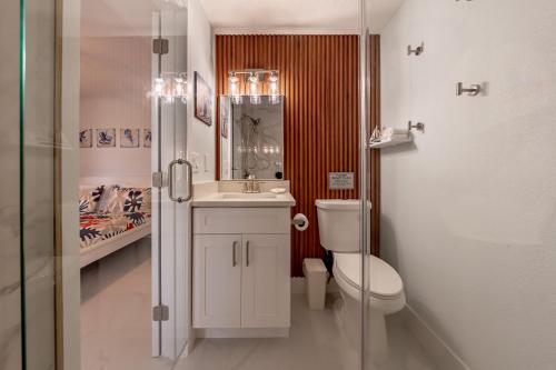 ein Badezimmer mit Toilette, Waschbecken und Spiegel in der Unterkunft Three Tides Apartments in Clearwater Beach