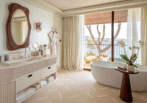 a bathroom with a tub and a large window at Mandarin Oriental Punta Negra, Mallorca in Palmanova