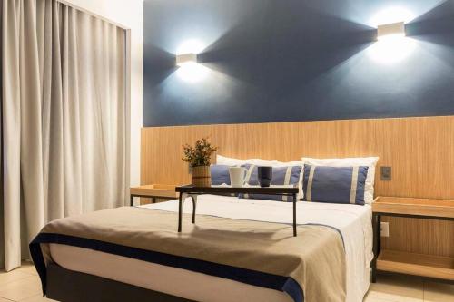 a bedroom with a large bed with a table on it at Transamerica Araraquara in Araraquara