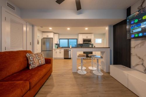 a living room with a couch and a kitchen at Three Tides Apartments in Clearwater Beach