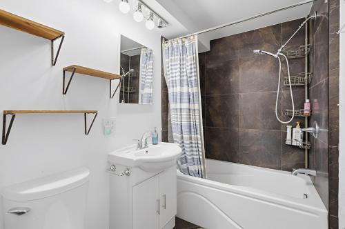 a bathroom with a sink and a tub and a toilet at The refuge of the slopes, ski in, ski out in Stoneham