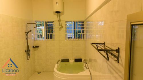 een badkamer met een bad in een kamer bij Lizabon Apartment Arusha in Nkoanrua