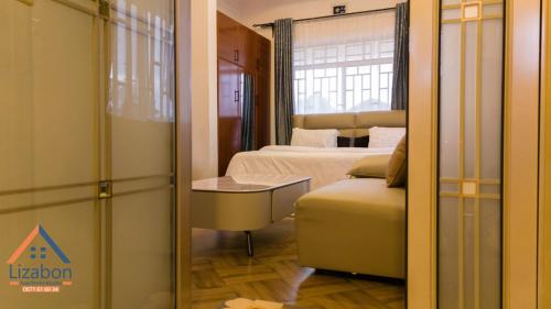 En eller flere senge i et værelse på Lizabon Apartment Arusha