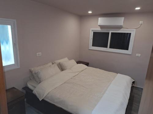 Ένα ή περισσότερα κρεβάτια σε δωμάτιο στο צימר ליד הים