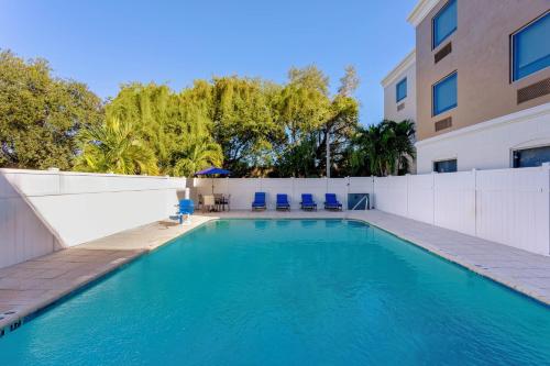 a swimming pool in front of a building at Holiday Inn Express & Suites Lantana by IHG in Lantana