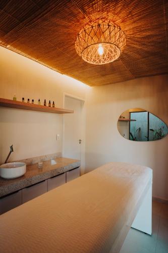 a bathroom with a bed and a sink and a mirror at Pousada Bosque da Serra in Crato