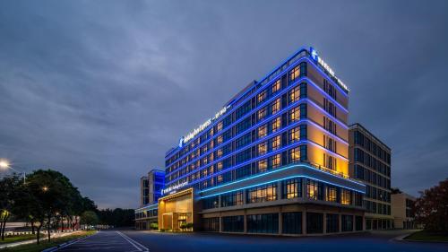 a tall building with blue lights on it at Holiday Inn Express Guangzhou Baiyun Airport T2 by IHG in Huadu