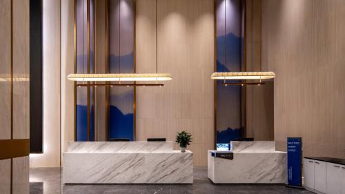 a lobby with two reception desks in a building at Holiday Inn Express Guangzhou Baiyun Airport T2 by IHG in Huadu