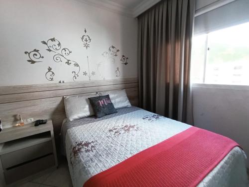 ein kleines Schlafzimmer mit einem Bett und einem Fenster in der Unterkunft Apartamento SUN - Barra Norte in Balneário Camboriú