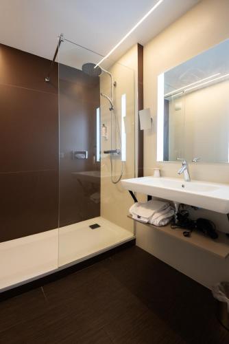 a bathroom with a sink and a shower at Mercure Brive in Ussac