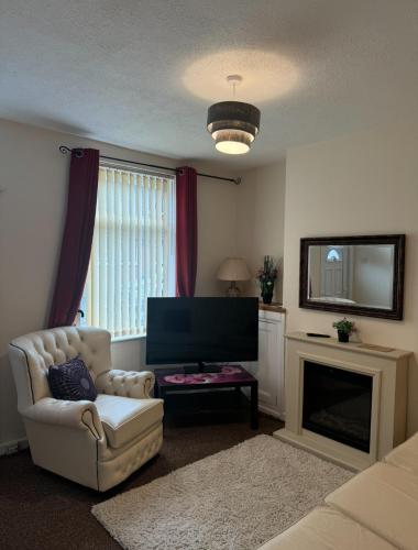 a living room with a chair and a television at Bentley View in Crewe