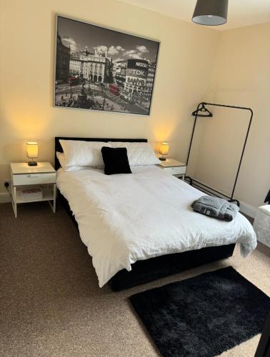ein Schlafzimmer mit einem weißen Bett und zwei Nachttischen in der Unterkunft Bentley View in Crewe