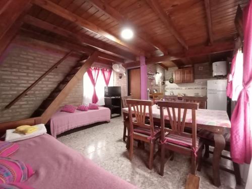 a room with two beds and a table and chairs at Cabañas Terra Natura in Bialet Massé