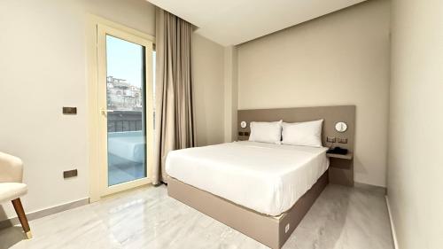 Un dormitorio con una cama y una ventana grande. en Viaje Hotel Downtown Cairo, en El Cairo