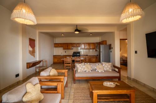 een woonkamer met een bank en een keuken bij Pacífico Surf in Brisas de Zicatela