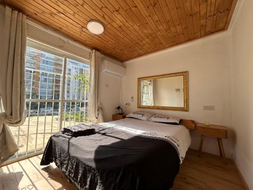 una camera da letto con un letto e una grande finestra di Kasa R a Herzelia
