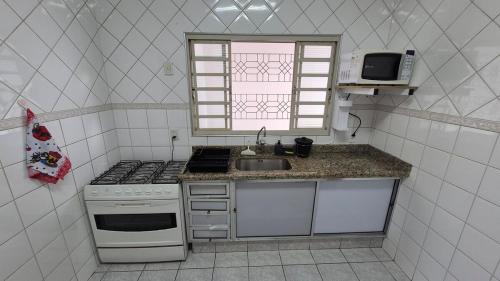 a small kitchen with a stove and a sink at Residencial Ana Jacinta in Campinas