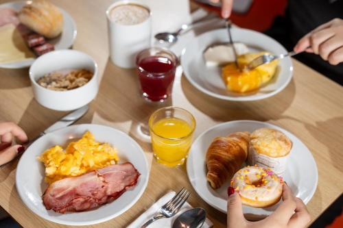 a wooden table with plates of breakfast food on it at Holiday Inn Express Porto Exponor by IHG in Leça da Palmeira