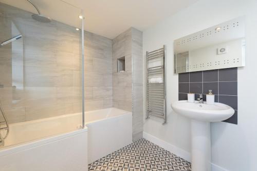 a bathroom with a shower and a sink and a tub at Large 4-Bedroom House in Banbury in Banbury