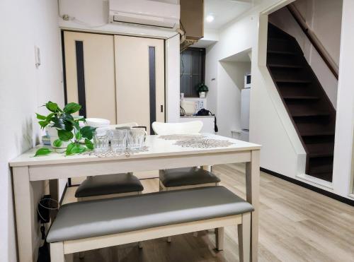 a dining room with a table and a staircase at D,A-House OSAKA in Osaka