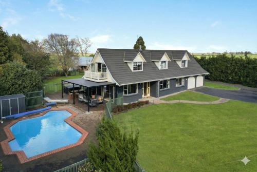 an aerial view of a house with a swimming pool at Hamilton Greenhill Lodge - Private Pool & Easy Highway Access in Hamilton