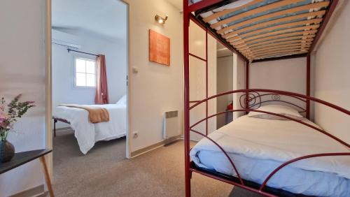 a bedroom with two bunk beds and a mirror at La Maisonnette du Soleil in Gallargues-Le-Montueux