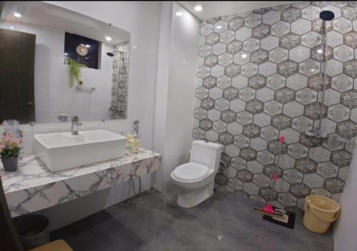un bagno con un water bianco e un lavandino di Giga Apartments & Sapphire Suite a Rawalpindi
