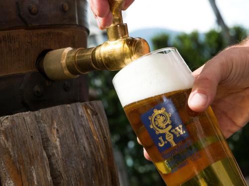 a person drinking a glass of beer from a tap at Hotel Blitzburg in Brunico