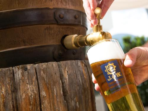 a person drinking a glass of beer from a barrel at Hotel Blitzburg in Brunico