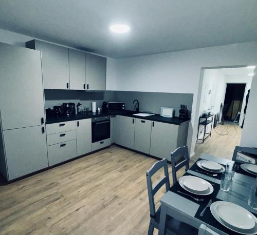 een keuken met witte kasten en een tafel met stoelen bij Apartment -Wohnung Herford in Herford