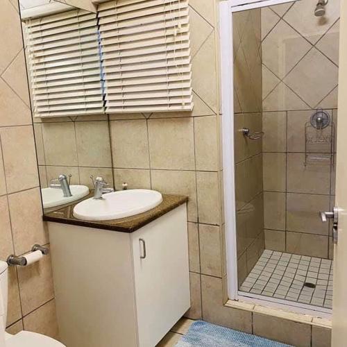 a bathroom with a sink and a shower at Cozy Oasis in Vanderbijlpark