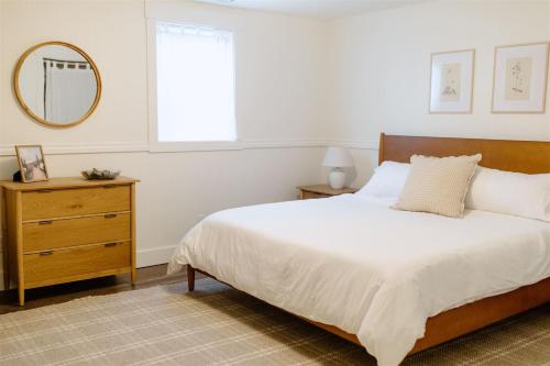 ein Schlafzimmer mit einem Bett, einem Spiegel und einer Kommode in der Unterkunft Boxwood Haven in Moscow